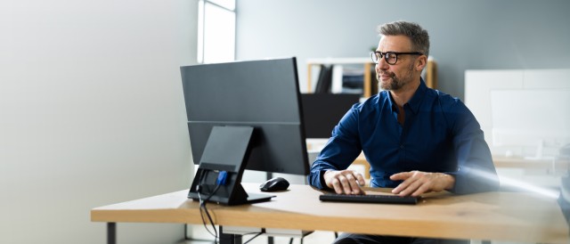 Mann sitzt in einem Büro vorm PC